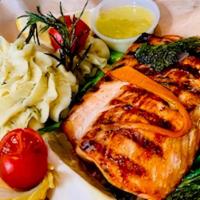 Grilled Salmon Filet · Blackened grilled, served with mashed potatoes, broccolini and caper jus.