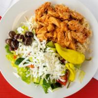 Chicken Shawarma Plate · Seasoned chicken over rice served with tahini sauce Greek salad and pita bread.