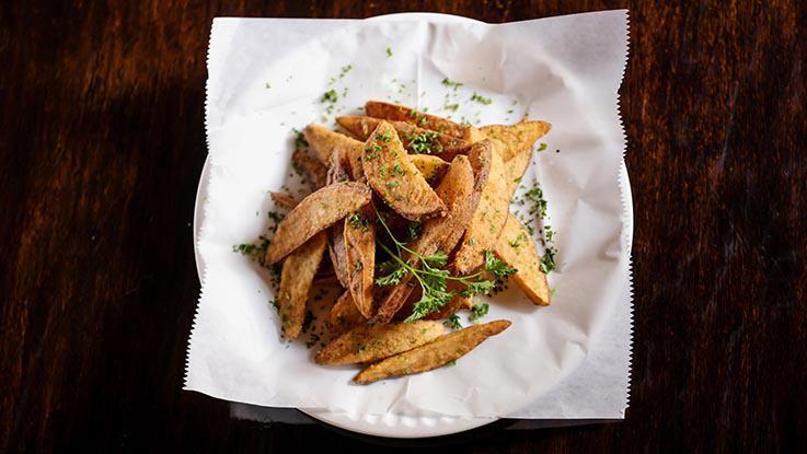 Potato Wedges · Fresh cut potato wedges fried to a golden-brown crisp.