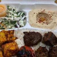 Beef & Chicken Shish Plate · 4 pieces of filet mignon and chicken shish served on a bed of rice, sides of salad and hummu...