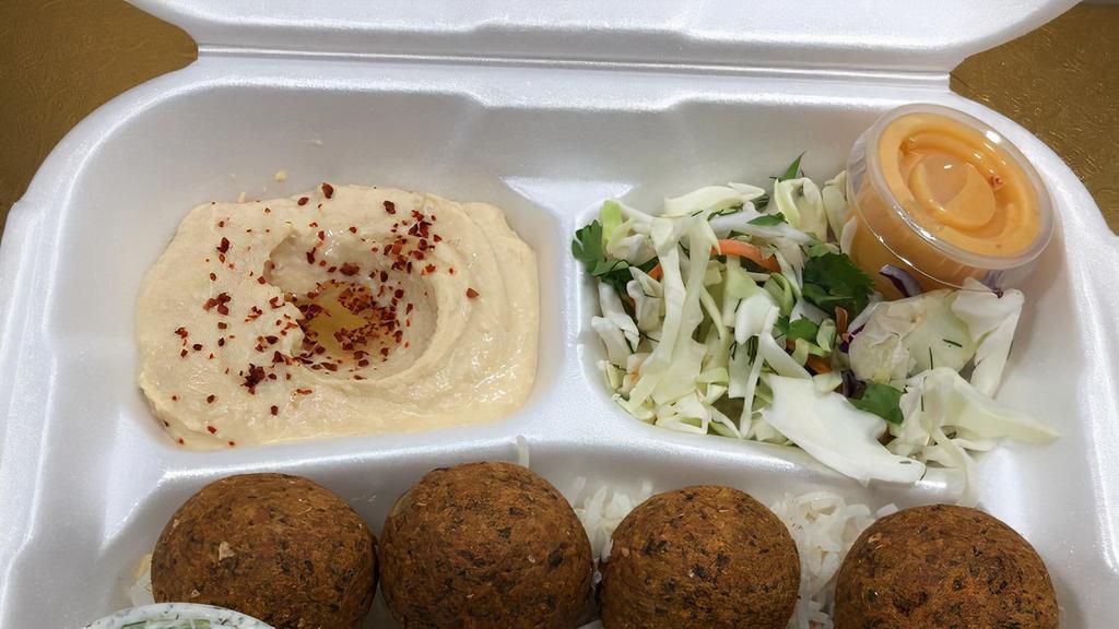 Falafel Plate · Falafel balls mixed with spices served on a bed of rice, sides of salad and hummus, topped with pita bread, and a side of tzatziki sauce.