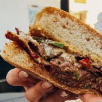 Chipotle Tri-Tip Sandwich · Chipotle, coffee smoked tri-tip, sautéed onions, bell peppers, mayo, crispy house cheese ble...