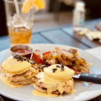 Eggs Benedict · Two poached eggs with Canadian bacon on an English muffin topped with hollandaise sauce and ...
