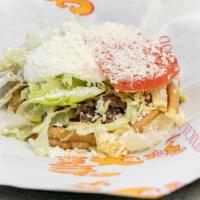 Carnitas Sope · Served with beans, lettuce, sour cream, cheese, and tomato.