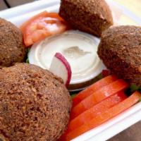 Falafel Plate · Falafel patties served on a bed of lettuce, tomatoes, pickles, and parsley. Includes one sid...