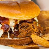Pulled Pork Sandwich With Slaw · House smoked pulled pork sandwich and a side of chips
