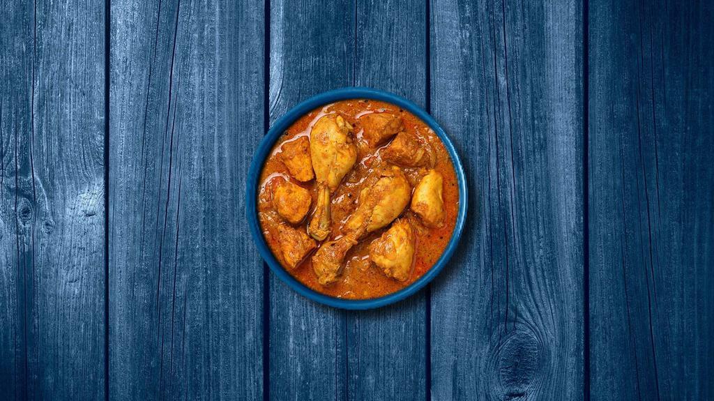 Capital Chicken Curry · Bone in/ boneless chicken pieces simmered in brown onion and tomato curry, seasoned with fresh herbs and whole Indian spices. Served with a side of aromatic white rice.