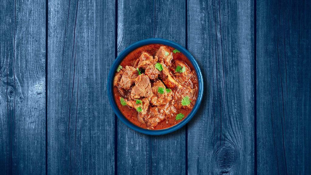 Capital Lamb Curry · Tender chunks of lamb simmered in a brown onion and tomato curry, seasoned with fresh herbs and whole Indian spices. Served with a side of aromatic white rice.