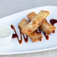 Fried Banana Spring Rolls · Spring roll wrappers filled with bananas, drizzled with chocolate, and served with coconut c...