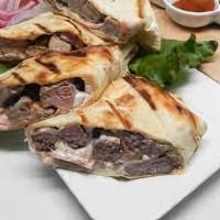 Beef Shawerma Sandwich · Thinly sliced marinated beef cooked on our rotisserie then cut and rolled in pita bread, wit...