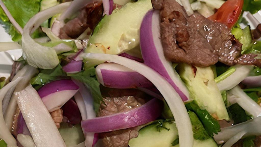 Yum Nuah (Beef Salad) · Grilled marinated beef tossed in lime dressing with white, red, green onions, cilantro, tomatoes, cashew nut and  cucumber.