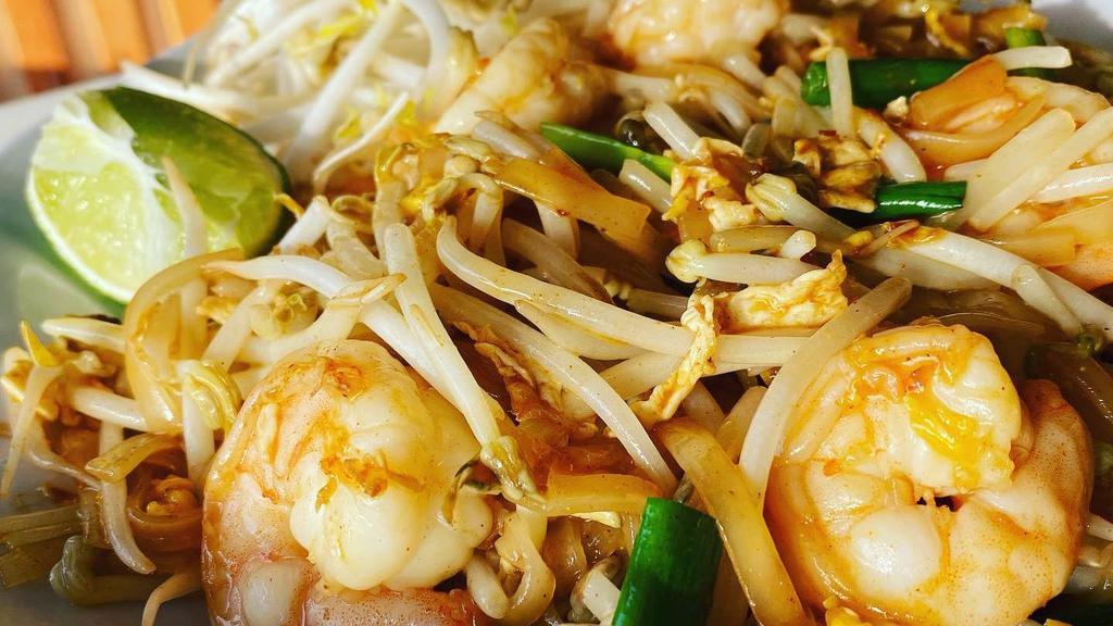 Pad Thai · Rice vermicelli stir-fried in tamarind sauce with an egg, bean sprouts, green onions, crushed peanut aside and a lime wedge.