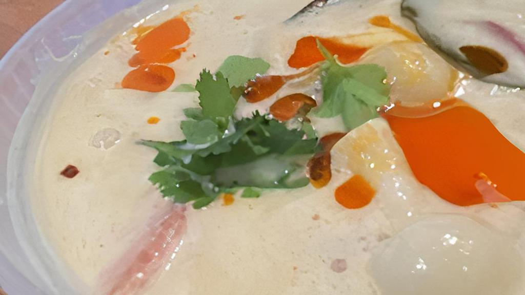 Tom Kha (Coconut Milk Soup) · Coconut lemongrass soup with mushrooms tomatoes, onions and topped with galangal and cilantro.