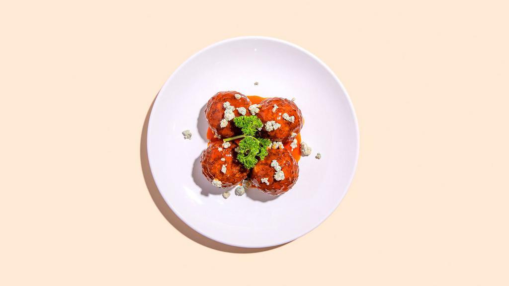 Buffalo Meatballs · Four meatballs slathered in buffalo sauce, and topped with crumbles of blue cheese and a drizzle of ranch.