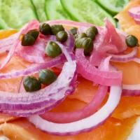 Lox Bagels · Cream cheese and smoked salmon on a toasted bagel. Topped with capers and onion, served with...