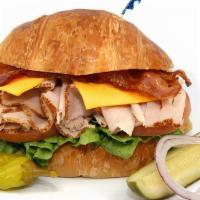 Turkey Club With Bacon Croissant Sandwich · Includes cheese (your choice), lettuce, tomato, and mayonnaise. Dill pickle spear, pepperonc...