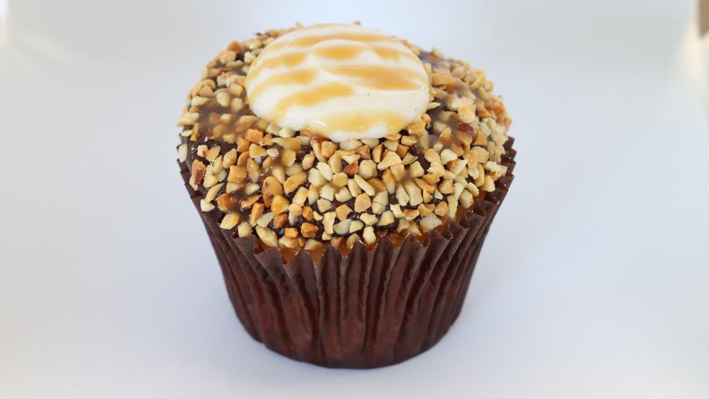 Chocolate Caramel Drum · Vanilla bean cake frosted with fudge dipped in peanuts and topped with vanilla bean buttercream and a drizzle of caramel.