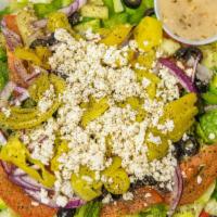 Greek Salad · mixed greens, red onion, tomatoes, cucumber, black olives, feta, vinaigrette on side.