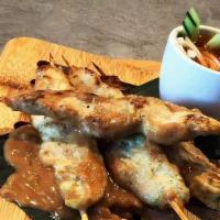 Chicken Satay · Grilled chicken on skewers, in turmeric-coconut milk and served with cucumber salad and pean...