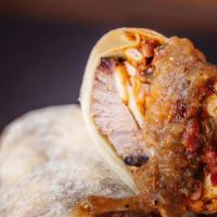 Brisket Breakfast Burrito · Eggs, brisket, tater tots, melted cheese, grilled onions, peppers, and tomatoes, guacamole.