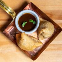 Samosa · A homemade deep fried pastry stuffed with mildly spiced potatoes, green peas, and cumin—serv...
