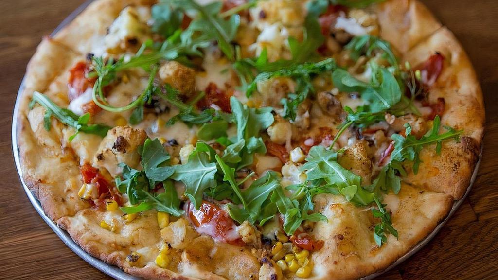 Cauliflower Heaven Pizza · 12'' Gluten-Free Cauliflower crust topped with juicy roasted garlic tomatoes, baked mushrooms, sweet corn and baked cauliflower, garnished with fresh arugula.