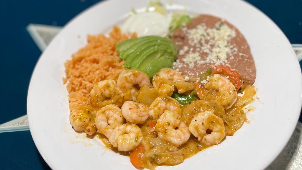 Mariscos A La Diabla · Shrimp sautéed in a pineapple diablo sauce with rajas. Served with red rice, refried beans and garnished with lettuce sour cream and avocado.