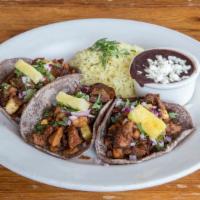 Al Pastor Tacos · spit-roasted marinated pork, pineapple, red onions, cilantro, cilantro-lime rice, black beans.
