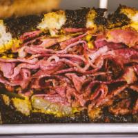 Pastrami · Thinly sliced pastrami piled high on marble rye. Served with mustard and pickles.