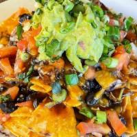 Nachos · House-made tortilla chips smothered in mozzarella & cheddar cheese, organic black beans, pic...