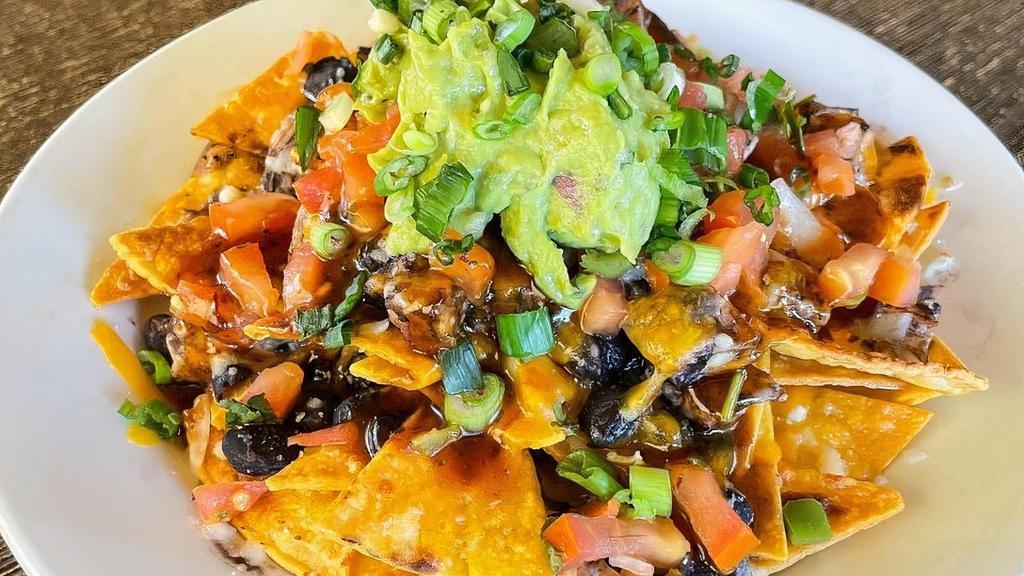 Nachos · House-made tortilla chips smothered in mozzarella & cheddar cheese, organic black beans, pico de gallo, guacamole, scallions, Ortega chilies, and a drizzle of honey chipotle. Choose natural chicken or grilled tofu filling. Gluten free. Can be vegan or vegetarian.