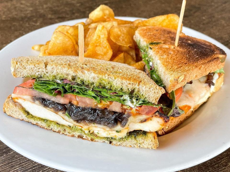 Chicken Pesto Sandwich · Grilled chicken breast with melted mozzarella, pesto, sliced tomato, grilled red onions, mixed greens and pepper mayo on bread of choice with a choice of side. Can be vegan, vegetarian or gluten free.  Contains pine nuts.