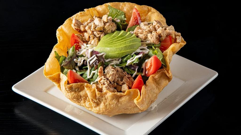 Tostada Chicken Salad · Tostada bowl filled with spring mix, grilled chicken, tomato, avocado, rice, refried beans, sour cream and cheese. Tossed in a mandarin dressing.