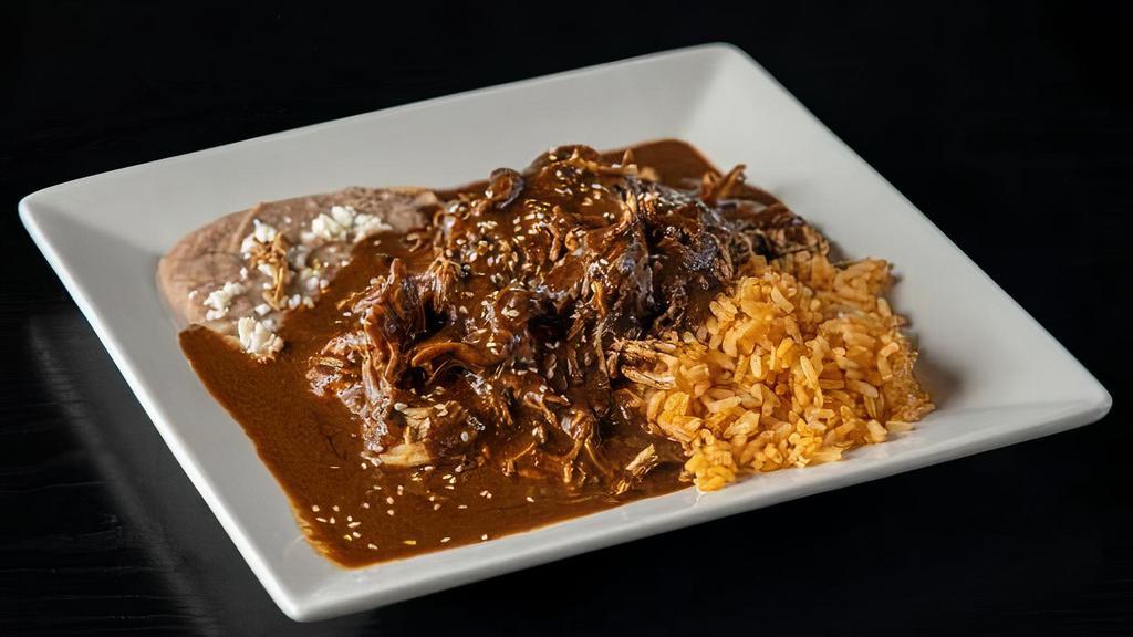 Mole Poblano · Shredded chicken covered in mole  poblano.  Served with rice, beans, and handmade soft corn tortillas.