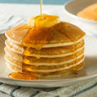 Stack Of Pancakes · Stack of four buttermilk pancakes with a side of syrup and toast