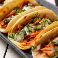 Al Pastor Tacos · Three of our classic tacos made of corn tortillas filled with juicy, marinated pork, onions,...