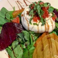 Burrata Salad · Burrata over spinach and sliced beets, topped with chopped tomatoes.
