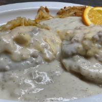 Cowboy Benedict · Our buttermilk biscuit, sausage patty, eggs, smothered in gravy. Served with potatoes or has...