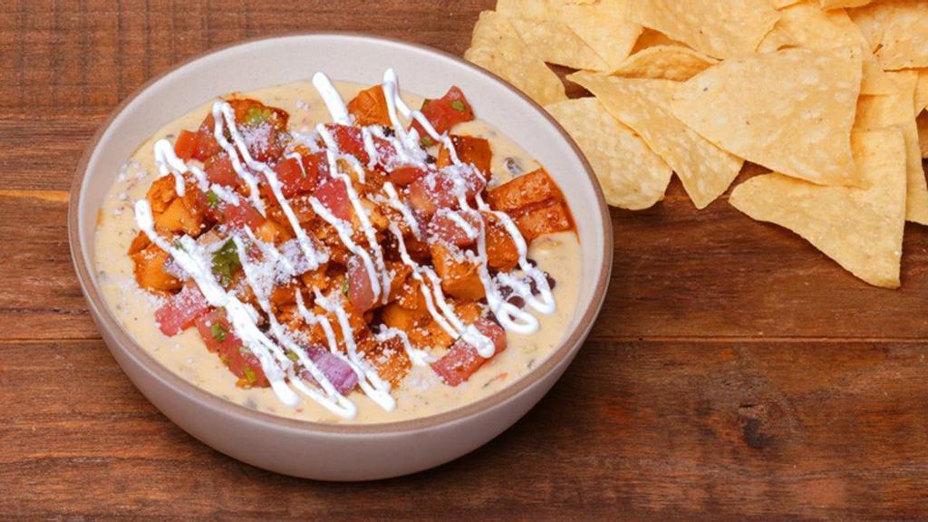 Hot-Bling Honey Chicken Loaded Queso · What's not to like.. It has all the toppings! QDOBA's classic three-cheese queso loaded with Cholula® Hot & Sweet Chicken, black beans, pico de gallo, sour cream, and cotija cheese. Served with chips on the side. You'll want to eat all of it, but be nice and share!