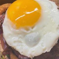 Pro Burger · 1/3lb Beef Patty Topped with Pastrami, Sunny Side up Egg, Onion Rings, and Avocado on a Sesa...