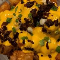 Loaded Tots · Tossed with bacon, spicy Cheddar/nacho cheese, and green onion.