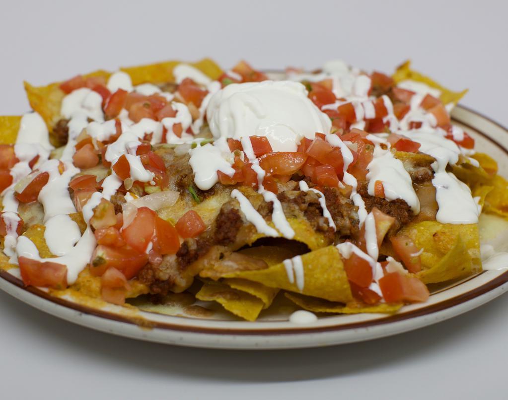Enchilada Nachos · Nachos topped with refried beans, melted cheese, tomatoes, green onions, enchilada sauce, guacamole and sour cream.