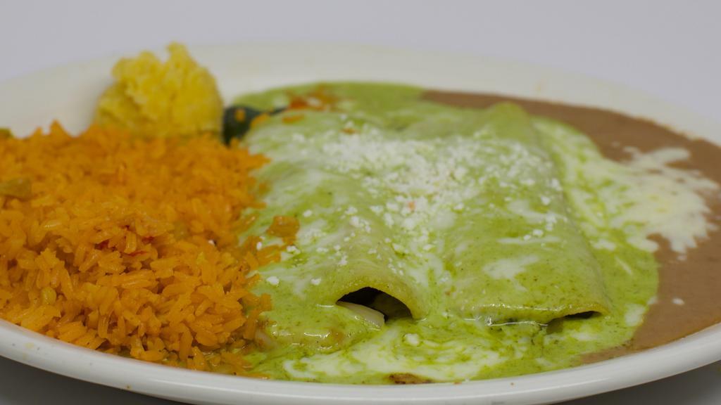 Veggie Enchiladas · Two corn tortillas stuffed with broccoli, cauliflower, onions, zucchini, and bell peppers. Topped with pesto sauce, Monterey jack cheese, and slices of fresh avocado.