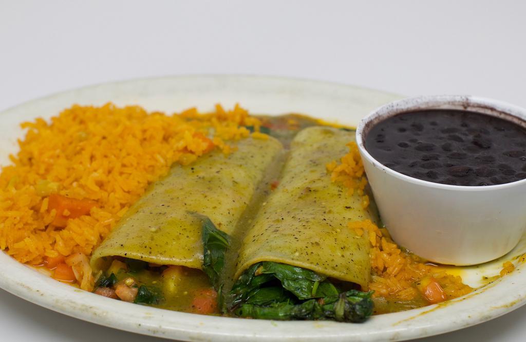 Enchilada De Espinaca · Two corn tortillas filled with spinach, onions, tomatoes, and mushrooms. Smothered in salsa Verde and garnished with avocado slices.