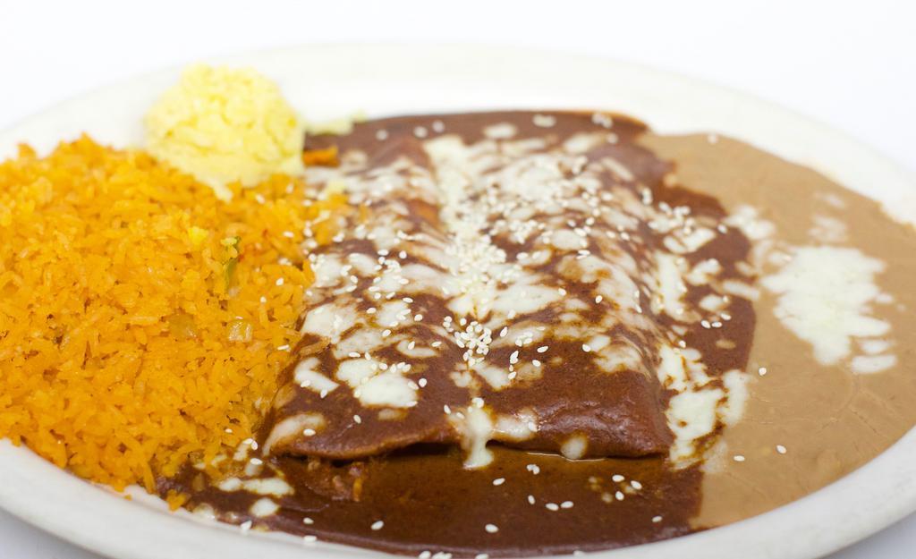 Enchilada De Mole · Two corn tortillas stuffed with tender chicken and topped with our delicious sweet, spicy Mexican mole sauce and sesame seeds try our Verde pipian version.