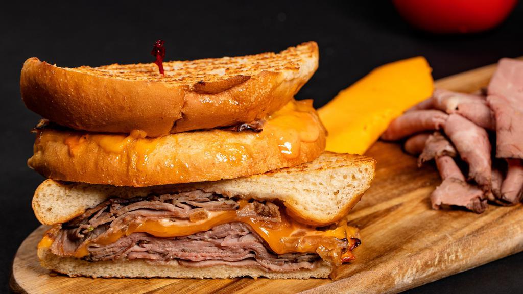 Roast Beef & Caramelized Onions · Roast beef with caramelized onions, cheddar cheese, and garlic mayo on a baguette.