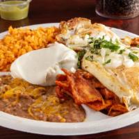 Chilaquiles Rojos O Verdes Plate · Tortilla strips with eggs, sauce, and sour cream on the side. Served with rice, beans, and t...