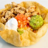 Grilled Chicken Taco Salad · Start with a fried flour tortilla then we add whole beans, shredded lettuce, cheddar- jack c...