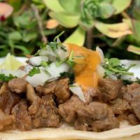 Asada Taco · Marinated steak chopped and grilled. Topped with onions, cilantro, and a mild sauce.