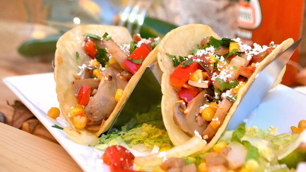 All-Veggie Taco · Street taco in a corn tortilla stuffed with corn, grilled bell peppers, mushrooms, and onions, all seasoned in garlic, and topped with dried cotija cheese and fresh cilantro.